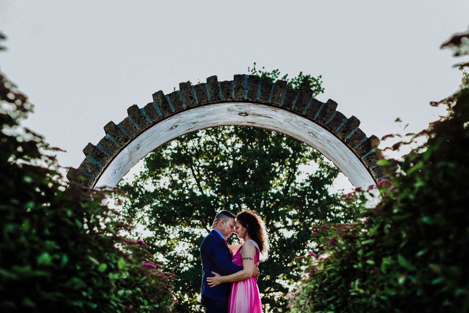 wedding-italy-bride-groom-hug-back light-green-sky-arch