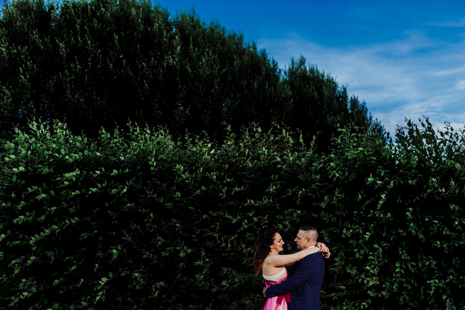 bride-groom-sky-green-bush-hug-look-wedding-italy