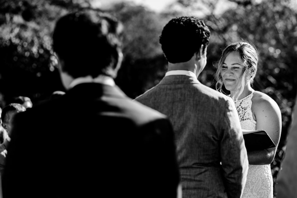 bride say the vows during the ceremony with a book on the hands