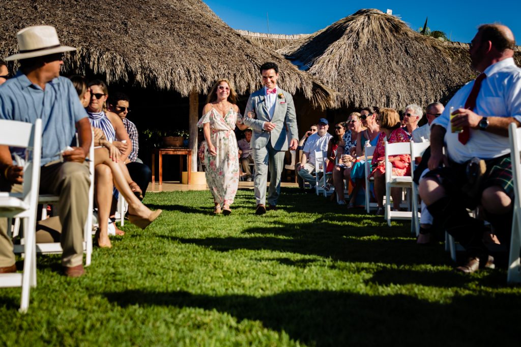 mum and groom walk together to the altar with the guest sitting for the ceremony