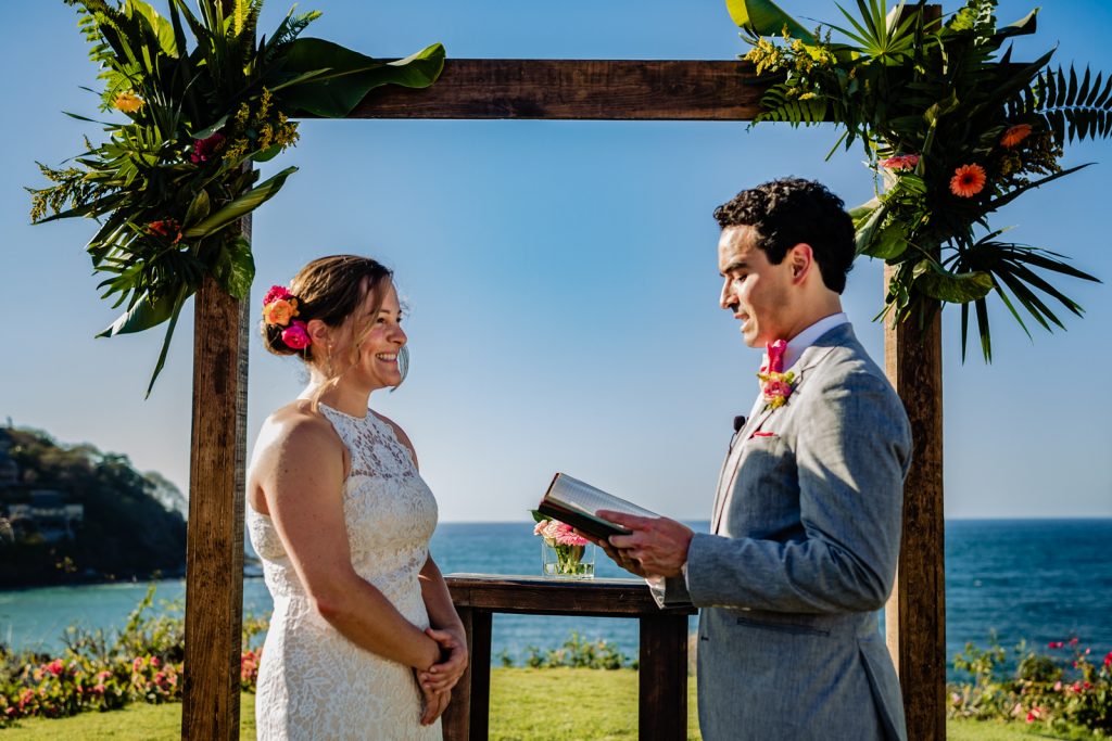 bride and groom during the ceremony with the vows with the ocean in the background