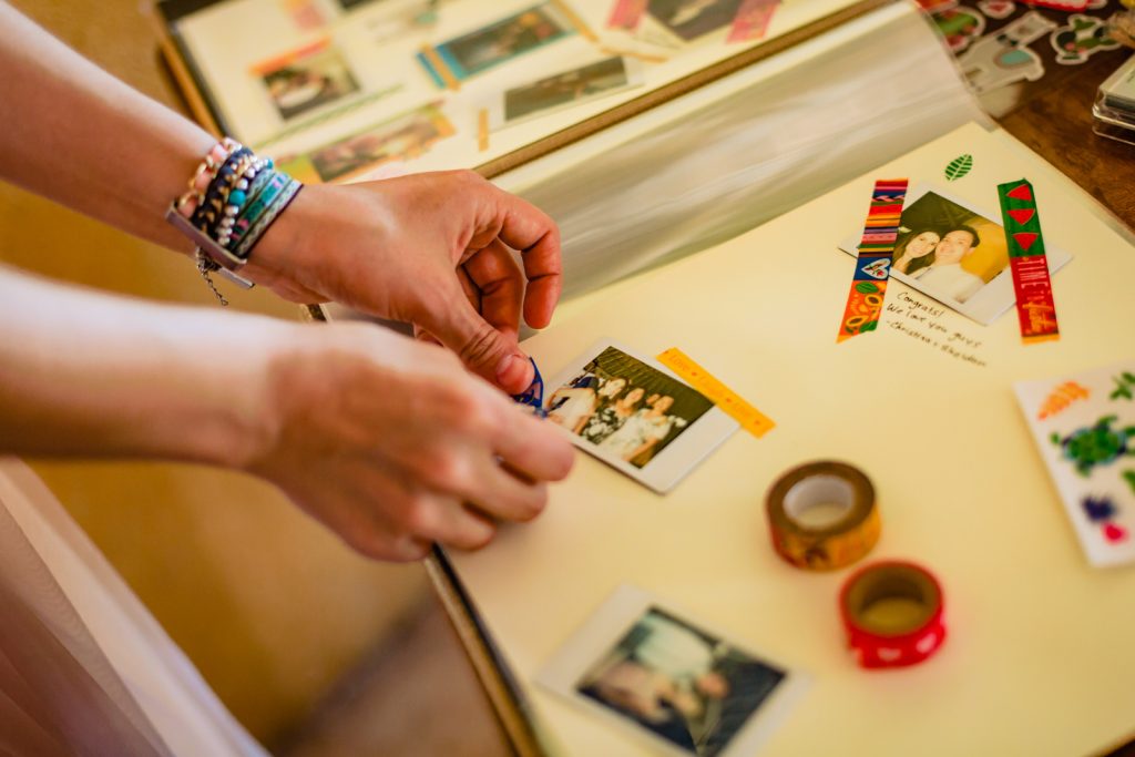 hands puts printed photos on the guest book