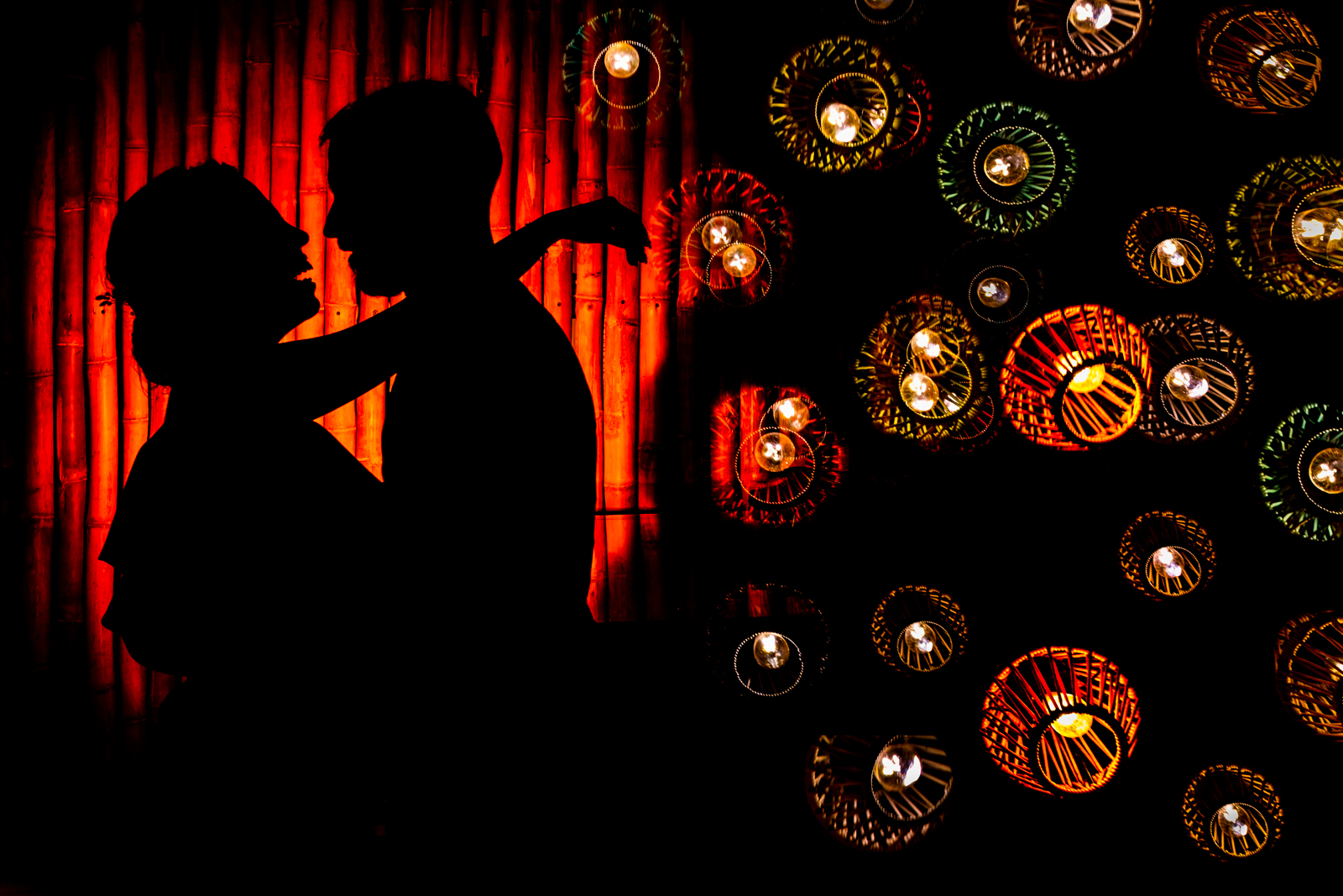 silhouette light bride and groom red wall, bride smile