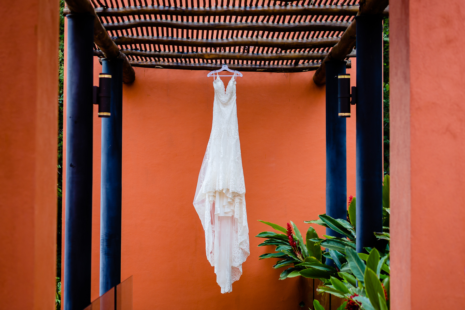 wedding dress hang on a red wall during a gettin ready