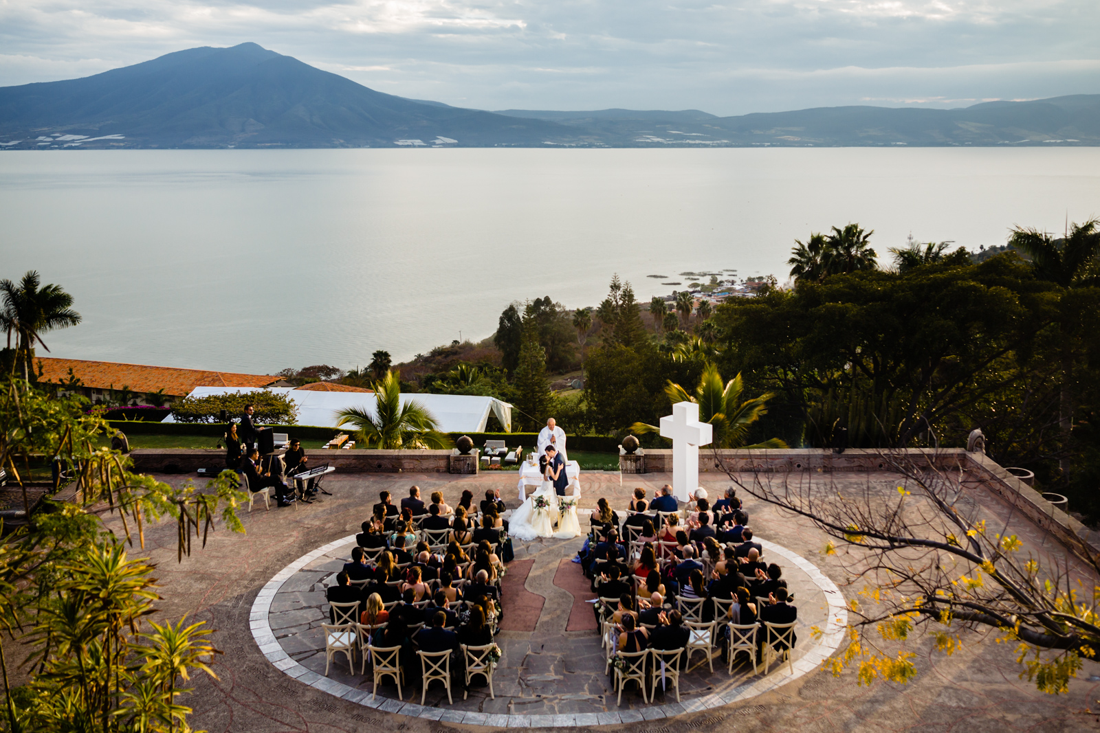 wedding on Chapala lake, bride and groom kissing with lake on the background 