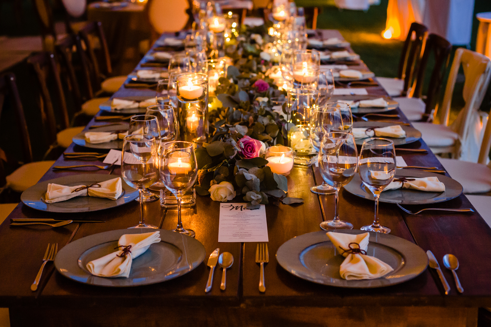 table with candles plates and all the set up for the wedding 