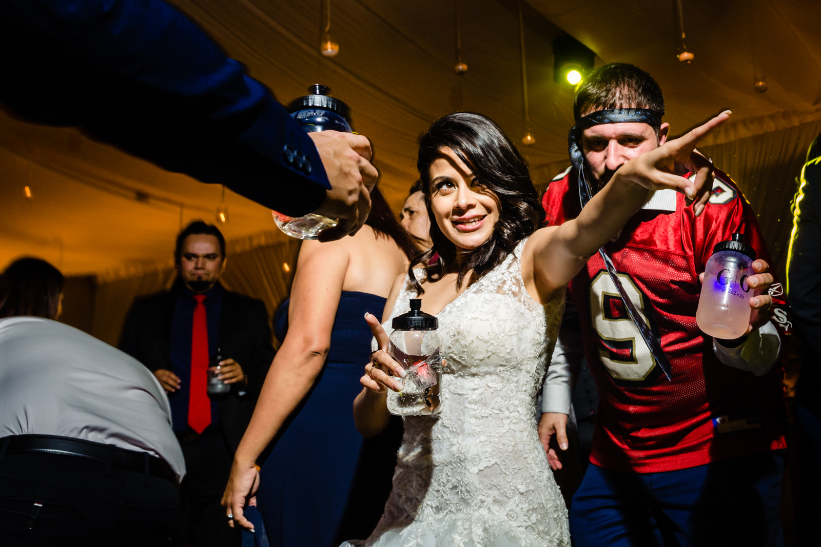 bride having fun on the dance floor dancing and drinking with friends 