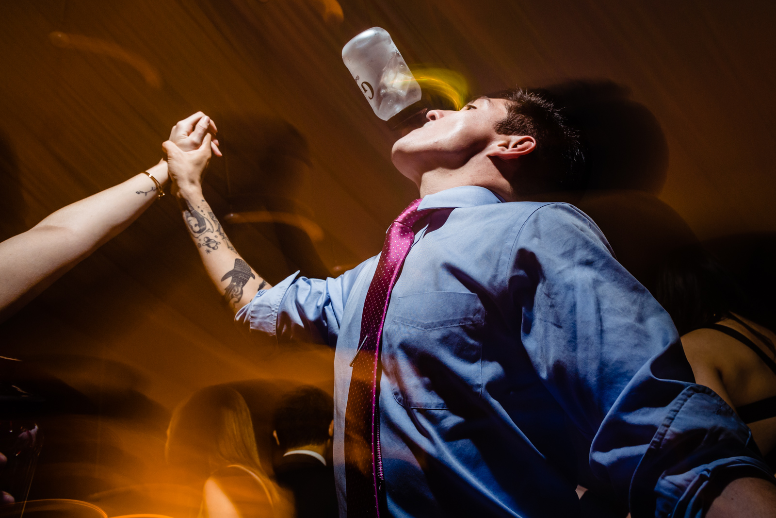 guy drink o the dance floor with drink on his mouth 