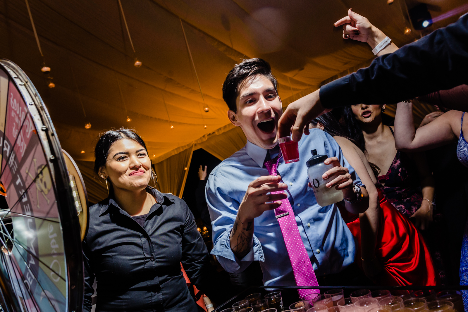 guys having fun during the wedding party drinking shots and smiling 