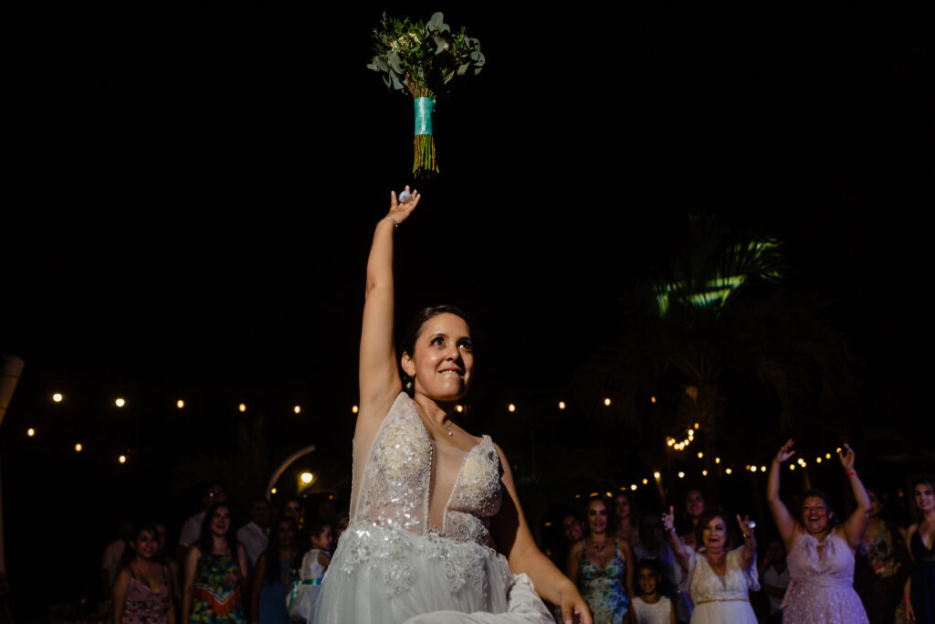 bride through the bouquet during the wedding at Hilton hotel with a group of girls on her background