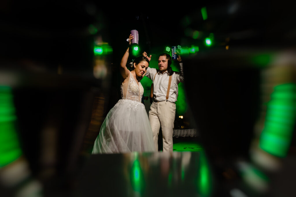 bride and groom dancing during the wedding party with green light