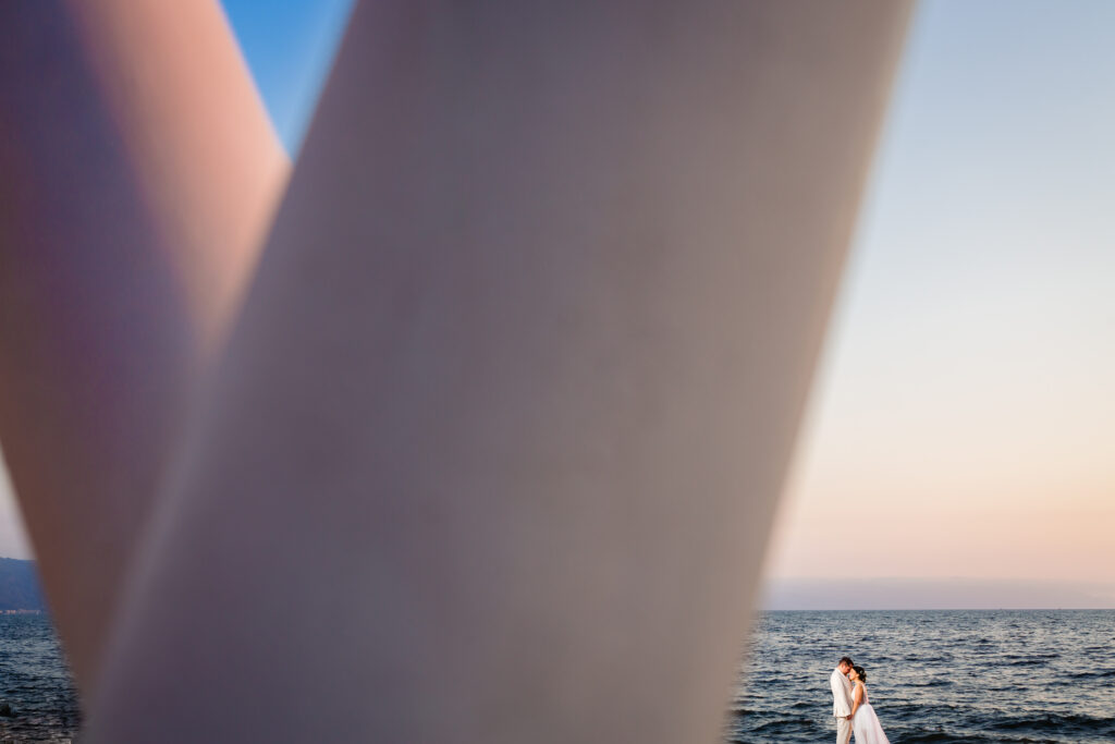 bride and groom hug on the beach during the sunset with the ocean on the background at Hilton resort Puerto Vallarta 