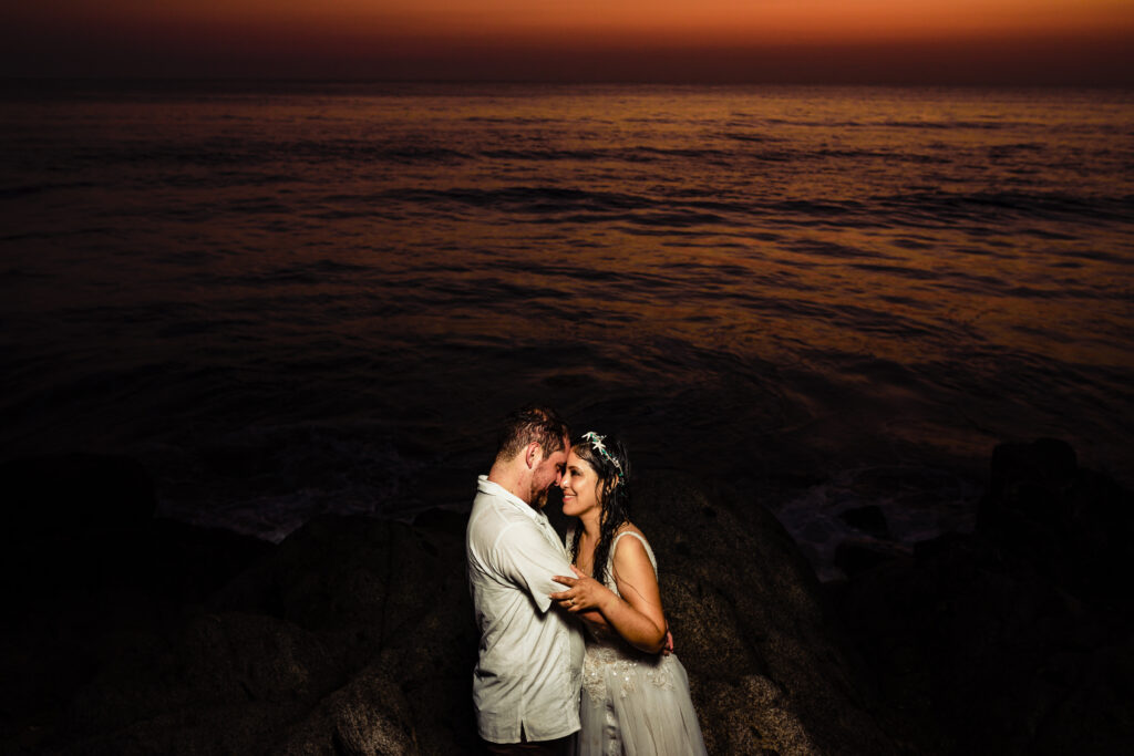 bride and groom hugs each other during the sunset time with a orange color on theyr background